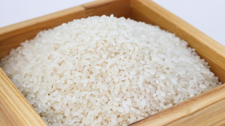 Uncooked white rice grains in a wooden box