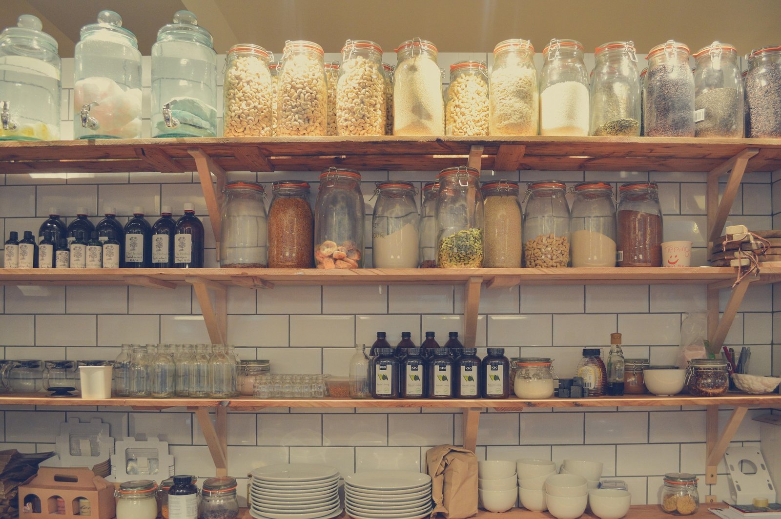 Wooden shelves filled with jars and glass containers of stored food
